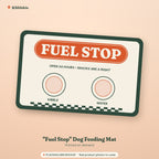 Placeholder mockup (not a final Printify product photo): printed dog feeding mat with a retro FUEL STOP sign, the line OPEN 24 HOURS, SNACKS ARE A RIGHT, two bowl circles labeled KIBBLE and WATER, and a checkered strip along the bottom